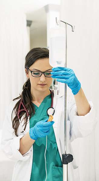 Young woman doctor anesthesiologist dressed in green gown, puts